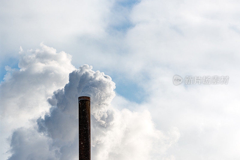 多云的天空，烟囱里的一条工业烟管。