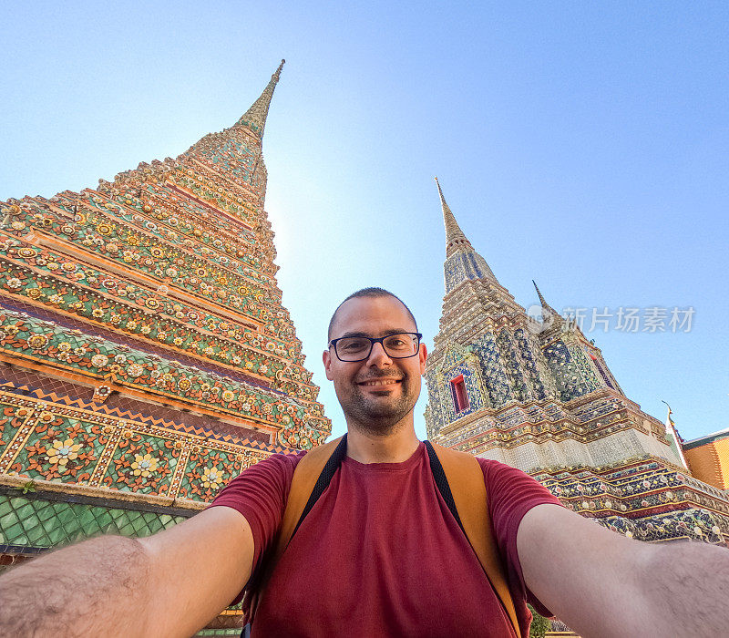 在泰国曼谷卧佛寺自拍的年轻人