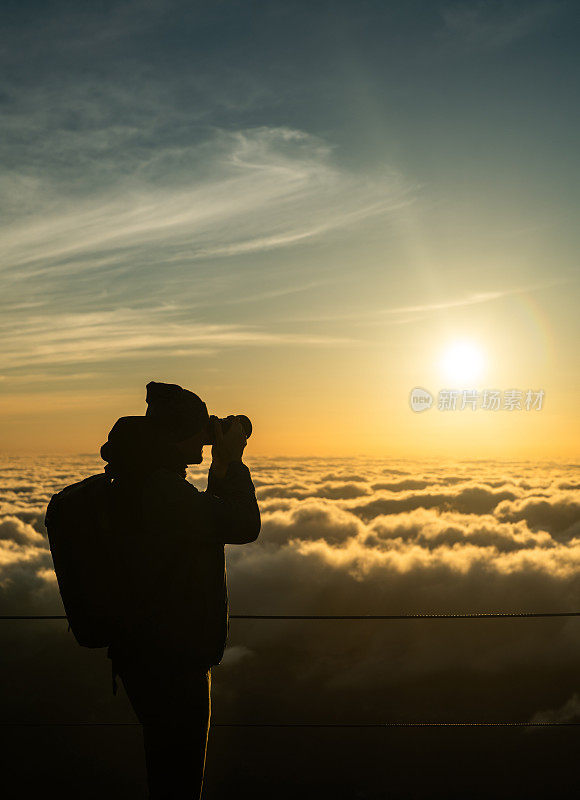 日落时的云海。游客从马德拉的山峰上欣赏风景并拍照