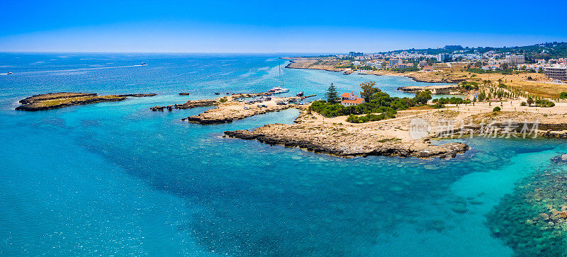 塞浦路斯的全景在一个阳光明媚的日子。地中海沿岸。珀涅拉港。海港里有一艘游艇。这座棕色屋顶的房子坐落在风景如画的海角上。休息、度假、放松