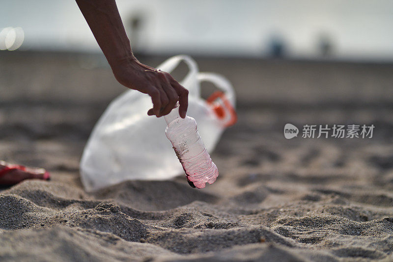 在海滩上捡塑料垃圾