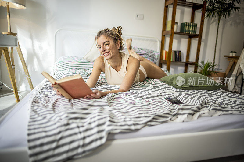 美丽的女人在床上看书