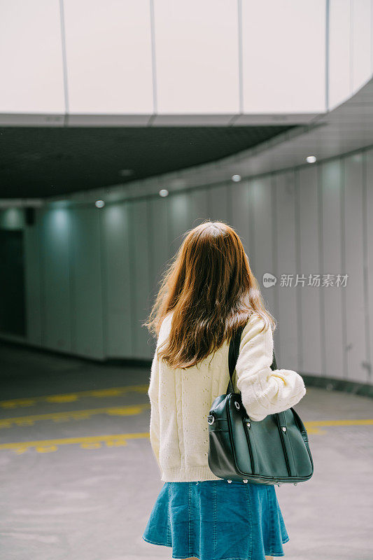 一个亚洲女孩在下午独自在隧道里回家