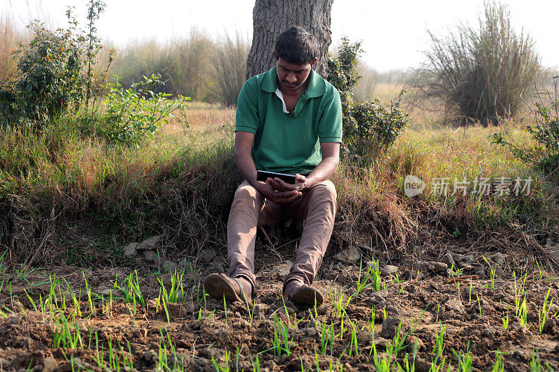 年轻的农民在户外使用手机