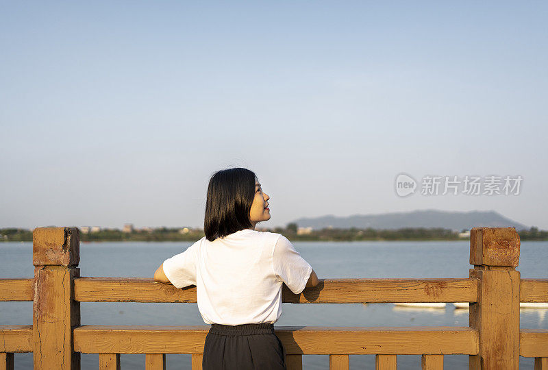 一位亚洲妇女在美丽的河边眺望远方