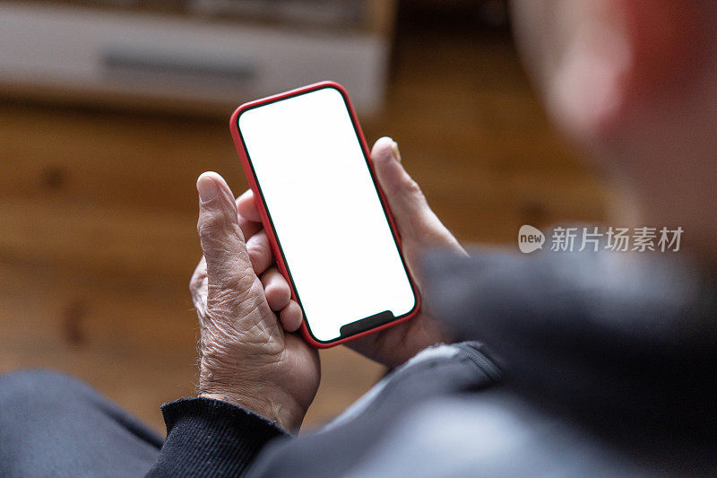 一个老人的手拿着一个白色屏幕的手机，特写