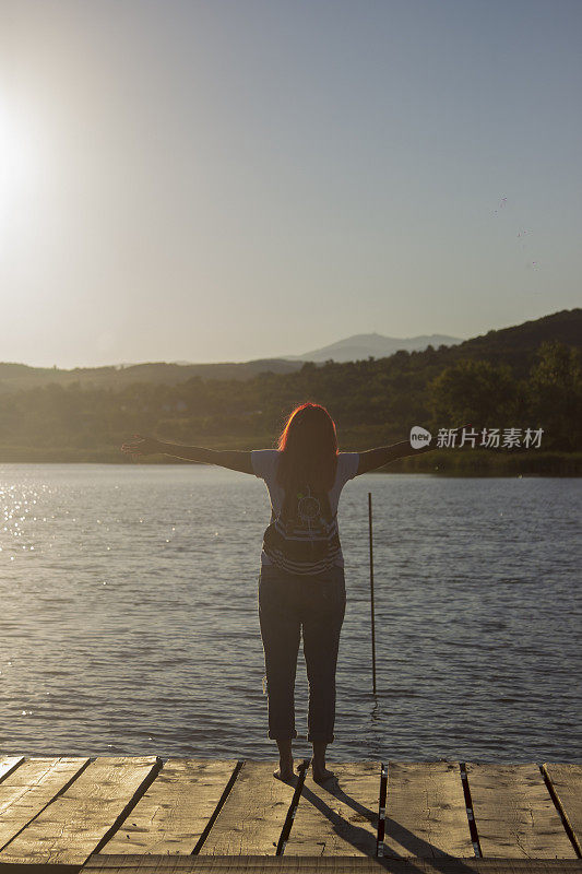 夕阳西下，年轻女子伸出双手