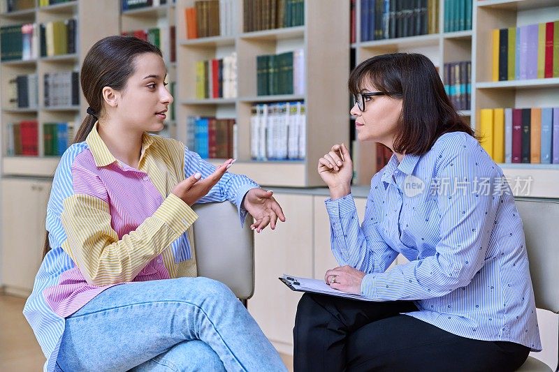 心理学家，高中生在图书馆为青少年学生提供行为咨询