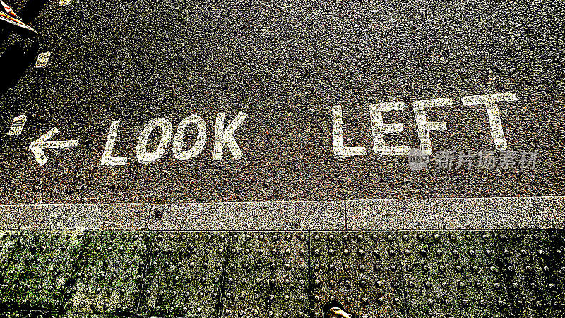 英国马路上画着“向左看”的标志，提醒行人和游客注意迎面而来的车辆
