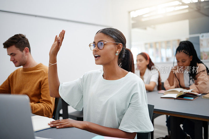 在大学里，学生通过提问进行教育，课堂上也有多样性。年轻女子在教室里举手提问，而同学在听。通过讨论来激励。