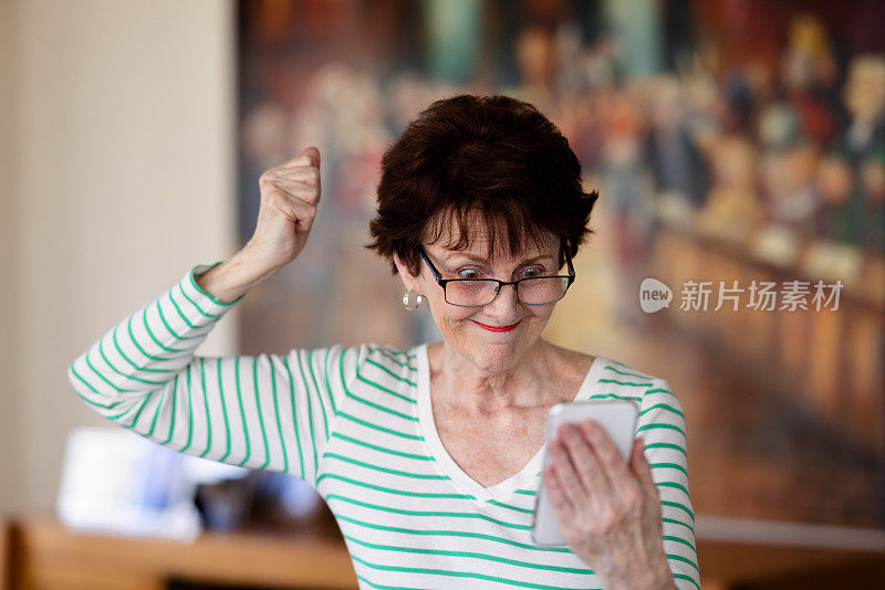 一名老年妇女对她的手机感到沮丧