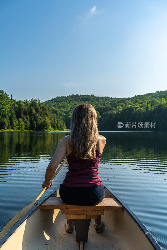 一个女人在清晨划独木舟。