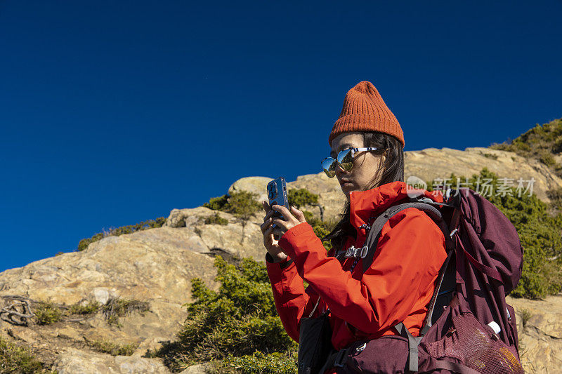 登山客在山顶使用智能手机。