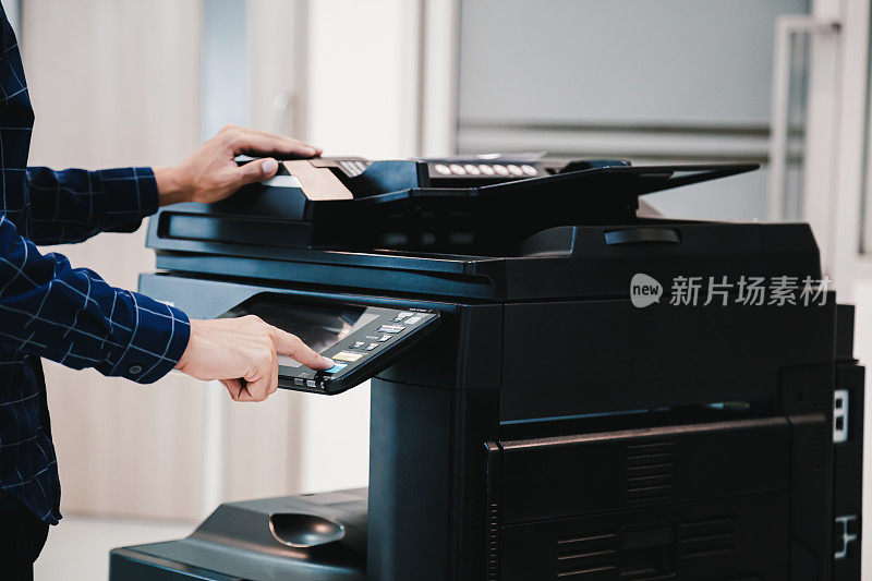 复印打印机，近身办公人员按下面板上的复印按钮，即可使用复印机或影印机扫描文件，打印一张纸。