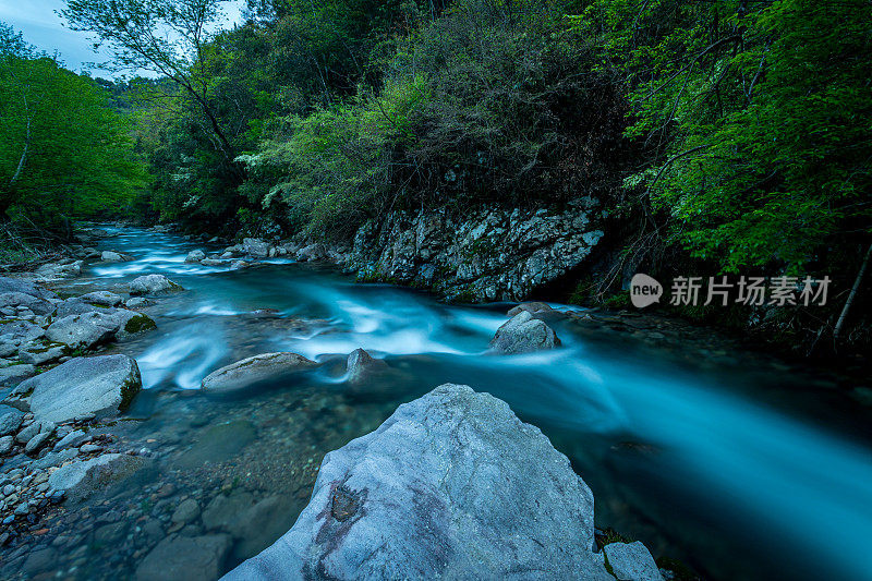 在黄昏时分，河流在山上急速流动。