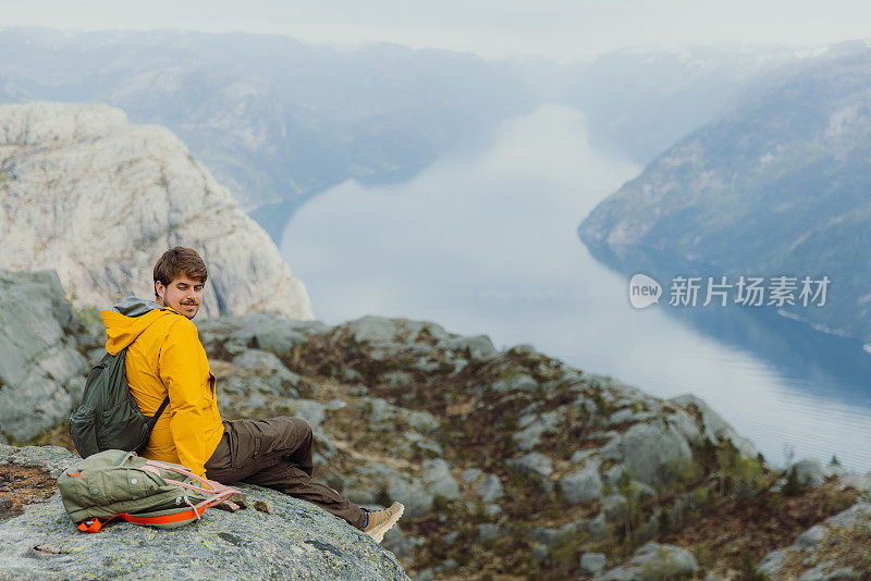 一个快乐的人从挪威风景优美的吕瑟峡湾俯瞰风景