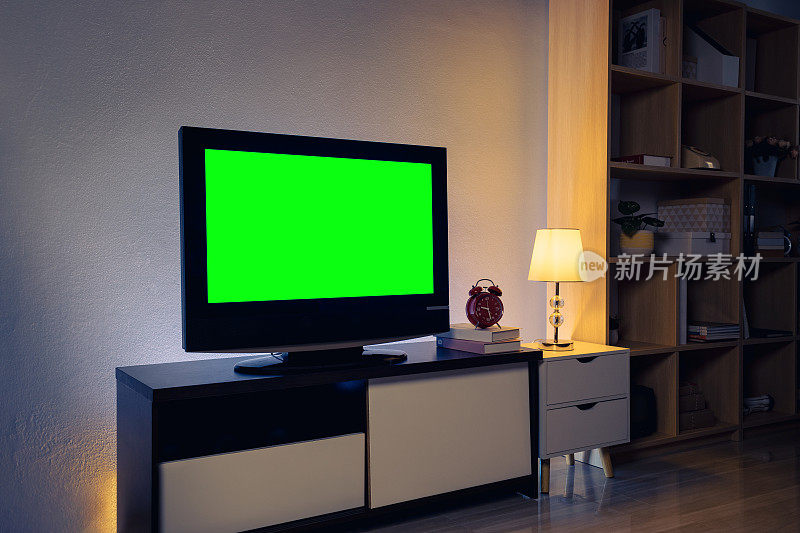客厅的橱柜上有绿色色度键的4K液晶电视，室内有白色的桌子和灯。舒适的客厅，室内设计