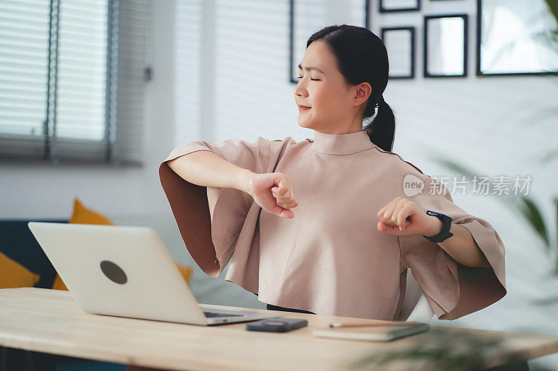 患有办公室综合症的亚洲女性坐在家里办公。