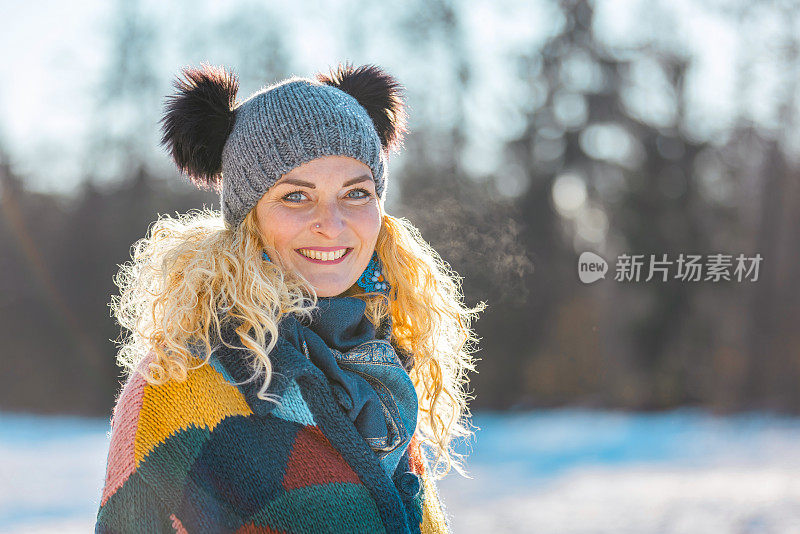 幸福的女人在冬天森林附近的白雪皑皑的草地