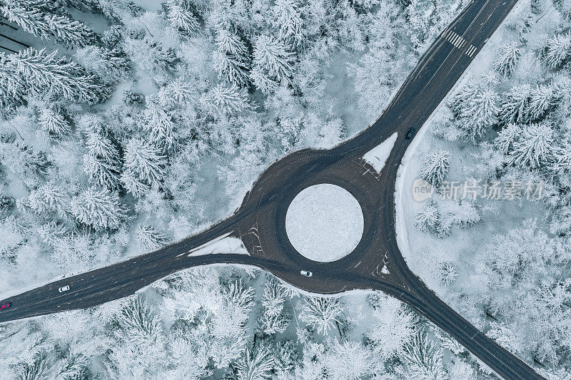 鸟瞰图交通环岛和道路路口在雪冬森林