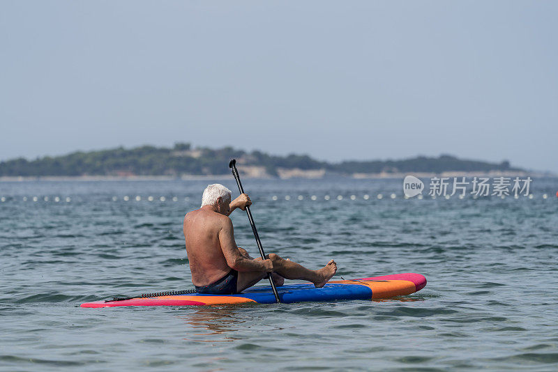 老年人坐在海浪上