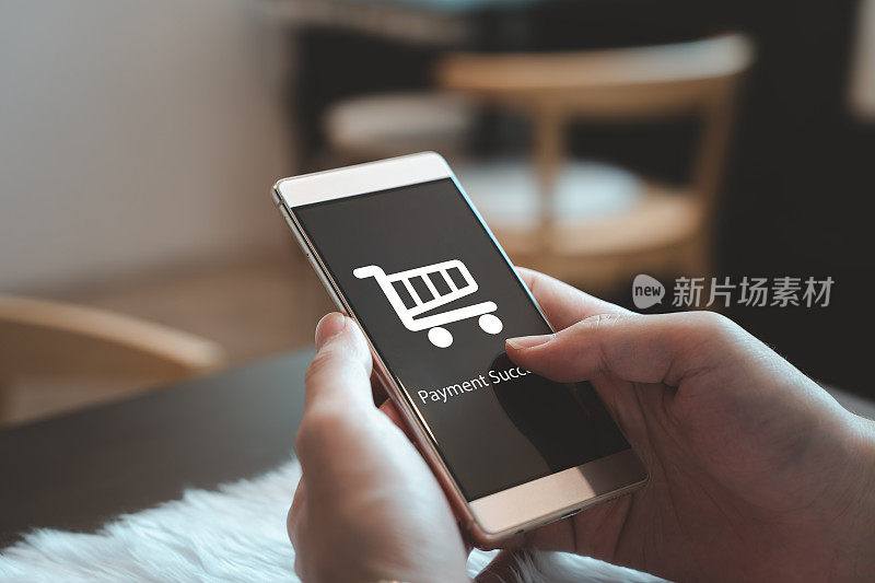 使用移动智能手机和应用程序显示网上购物符号和支付成功消息的人。