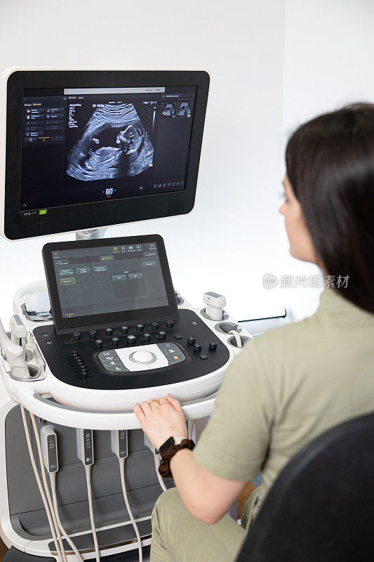 妇产科医生为孕妇做超声波扫描。