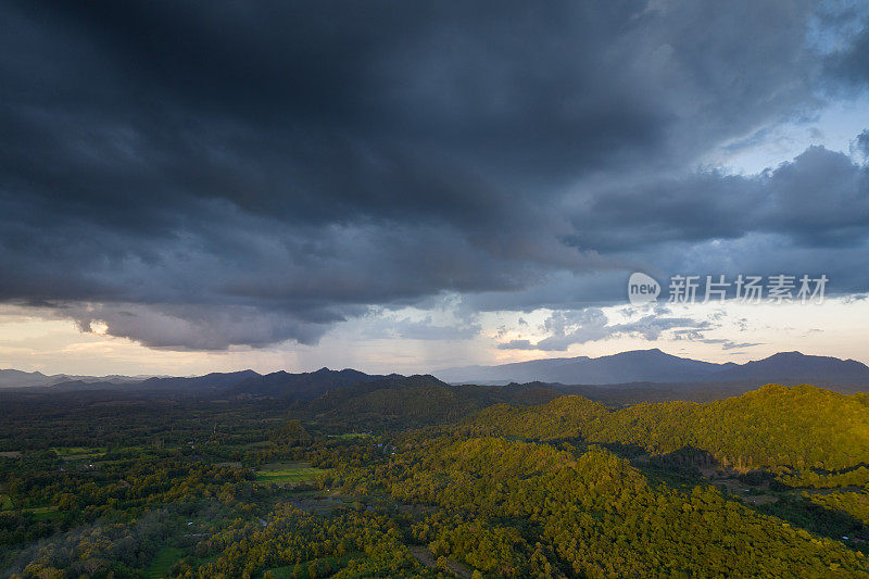 巨大的黑色雨云和暴雨落在山区的森林地区。