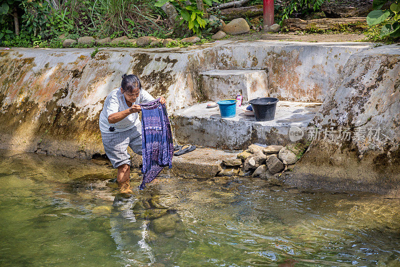 一个女人在河里洗衣服
