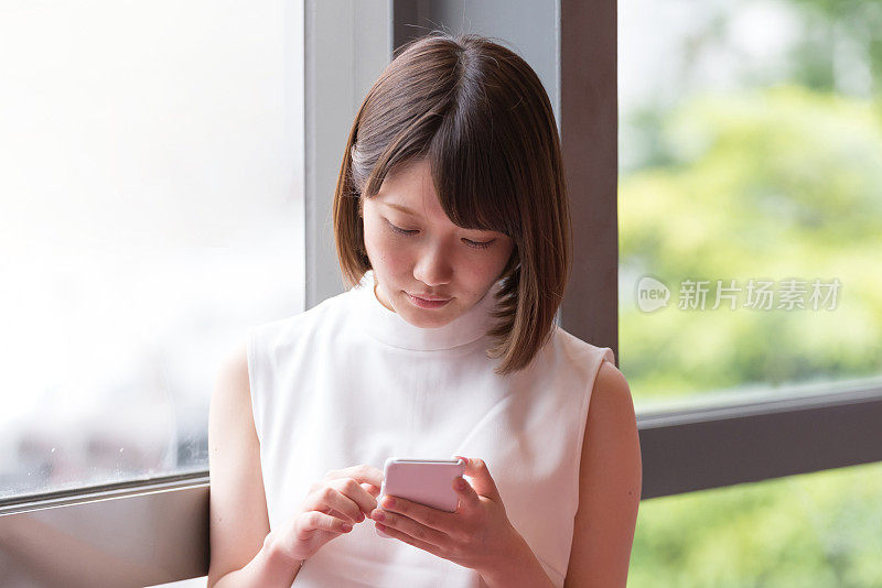 一名日本年轻女子正在使用智能手机