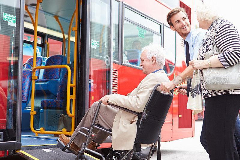 司机帮助老年夫妇通过轮椅坡道登上巴士
