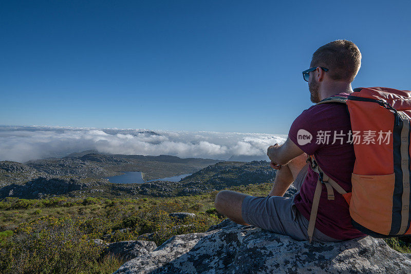 一个年轻人在开普敦山顶上看风景