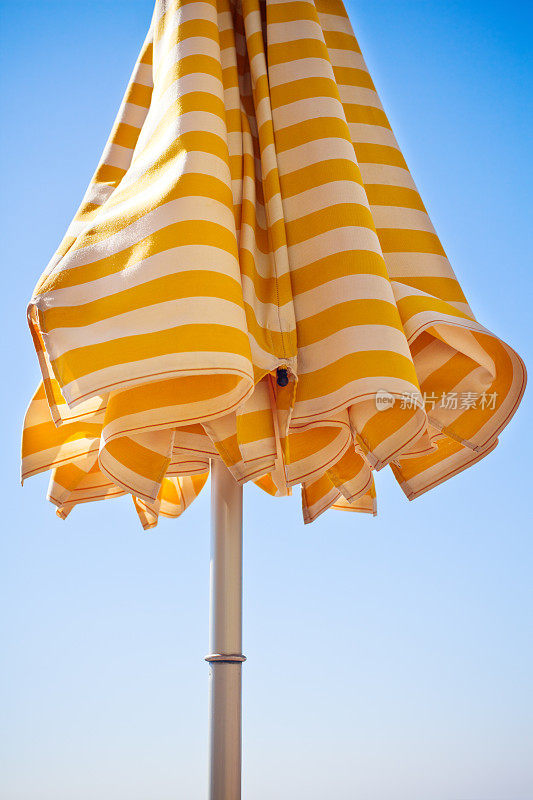 黄色的沙滩伞盖着蓝色的天空
