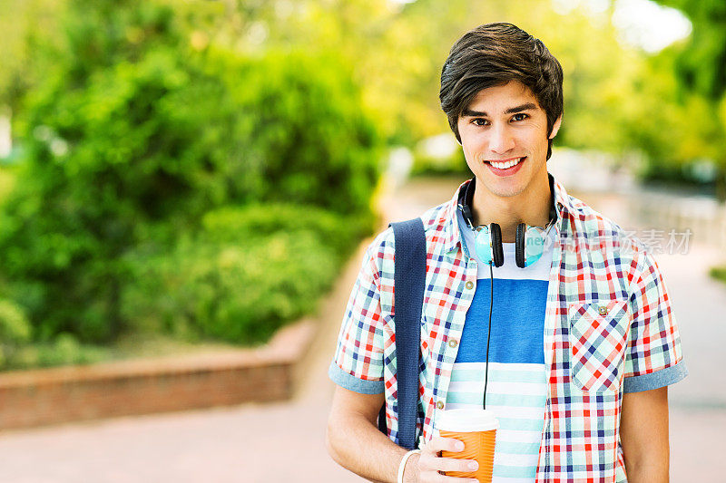 校园里用一次性咖啡杯的男学生