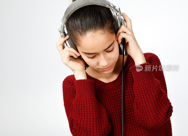 年轻女孩戴着耳机听音乐