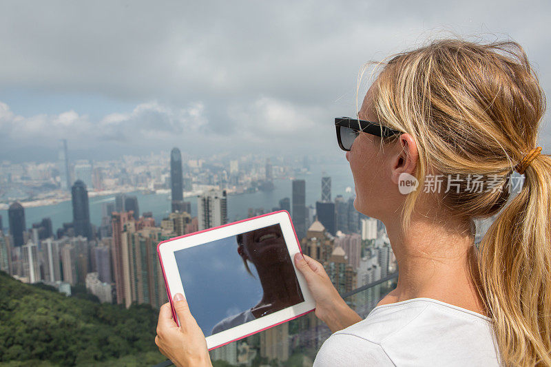 女游客用数码平板电脑拍摄香港风景