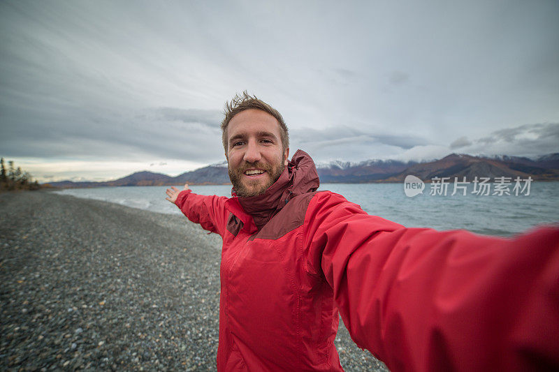 一名在加拿大旅游的年轻人在湖边自拍。