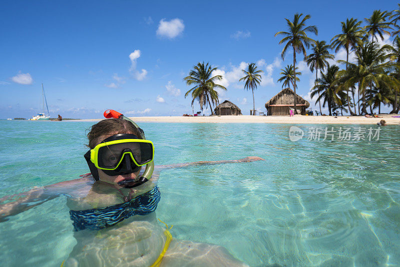 资深妇女喜欢在加勒比海佩罗岛附近戴着水肺面具游泳