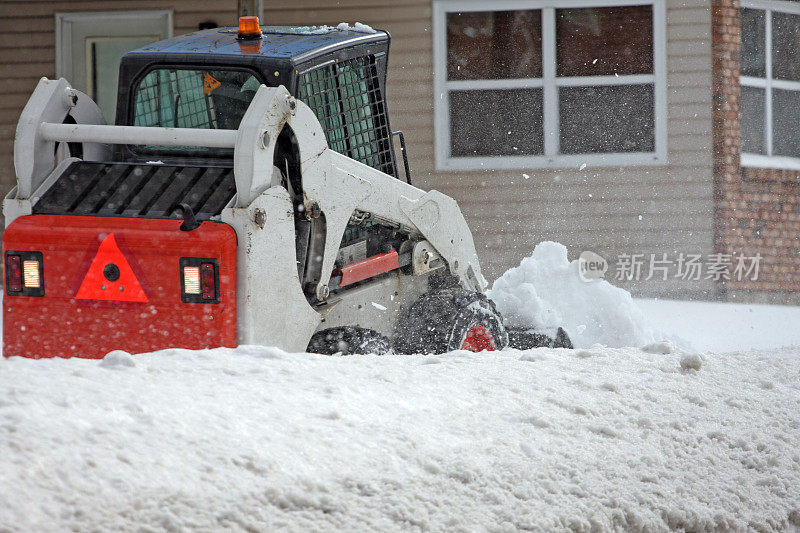 迷你装载机在清扫居民区人行道上的积雪