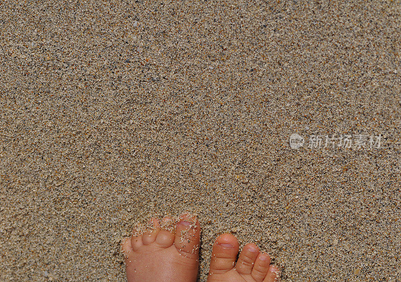 婴儿的脚在沙子里