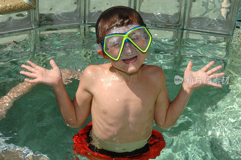 小男孩戴着面具游泳