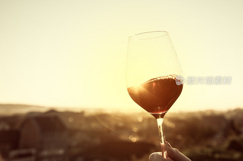 日落时分，用水晶酒杯盛红酒