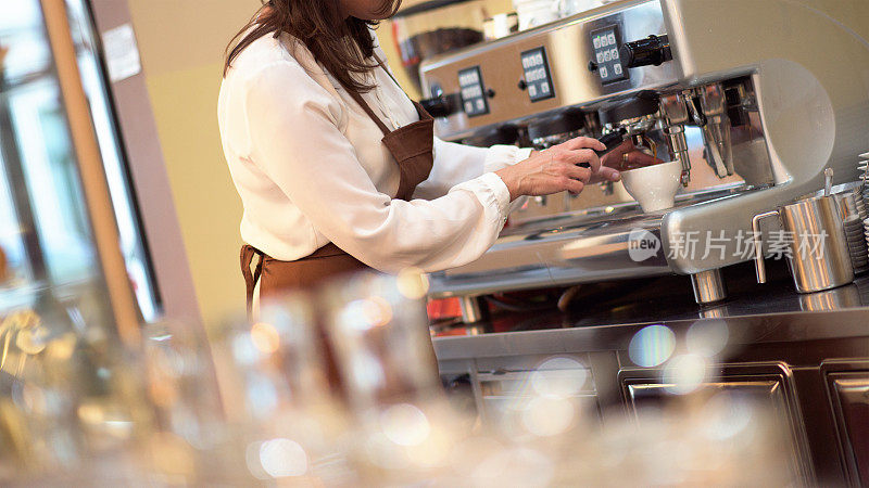 女服务员用咖啡机煮咖啡