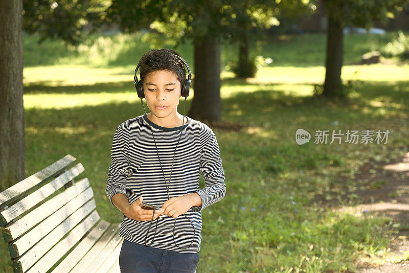 小男孩在用智能手机听音乐