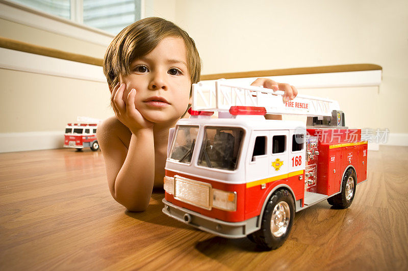 带着玩具消防车的男孩