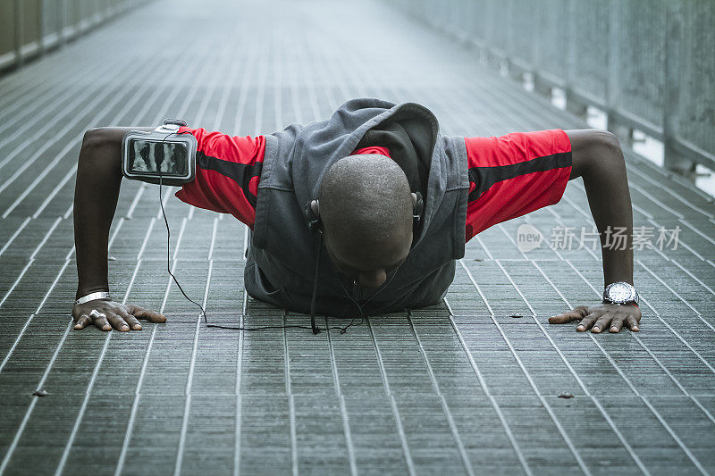 一个年轻人在铁桥上做俯卧撑