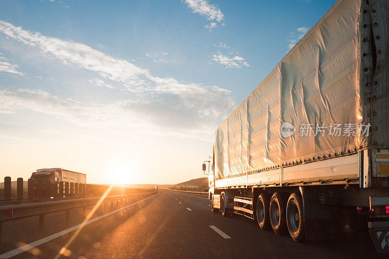 黄金时段，白色卡车在高速公路上运送货物