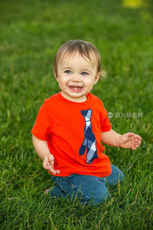 1岁男孩在外面的草地上玩