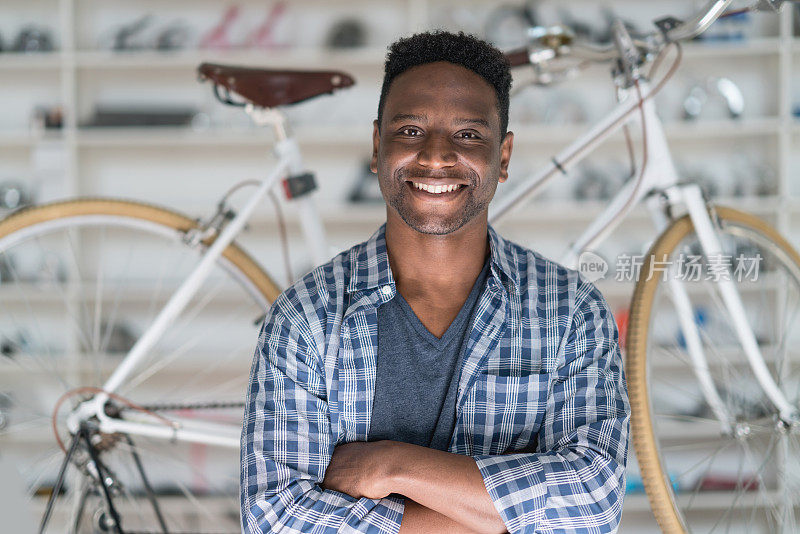 拉丁美洲黑人企业主的自行车修理店看着照相机微笑