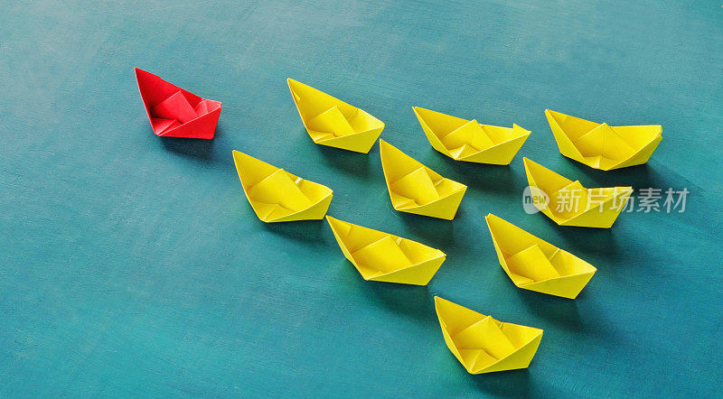 领导理念红色领导纸船从一群黄色小船中脱颖而出